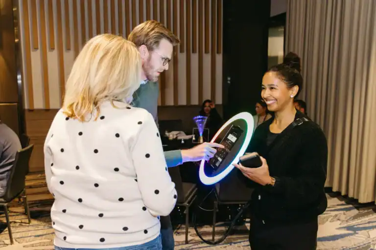 An attendant helps guests frame the shot and get a smooth, fast photo-booth experience anywhere in the venue.