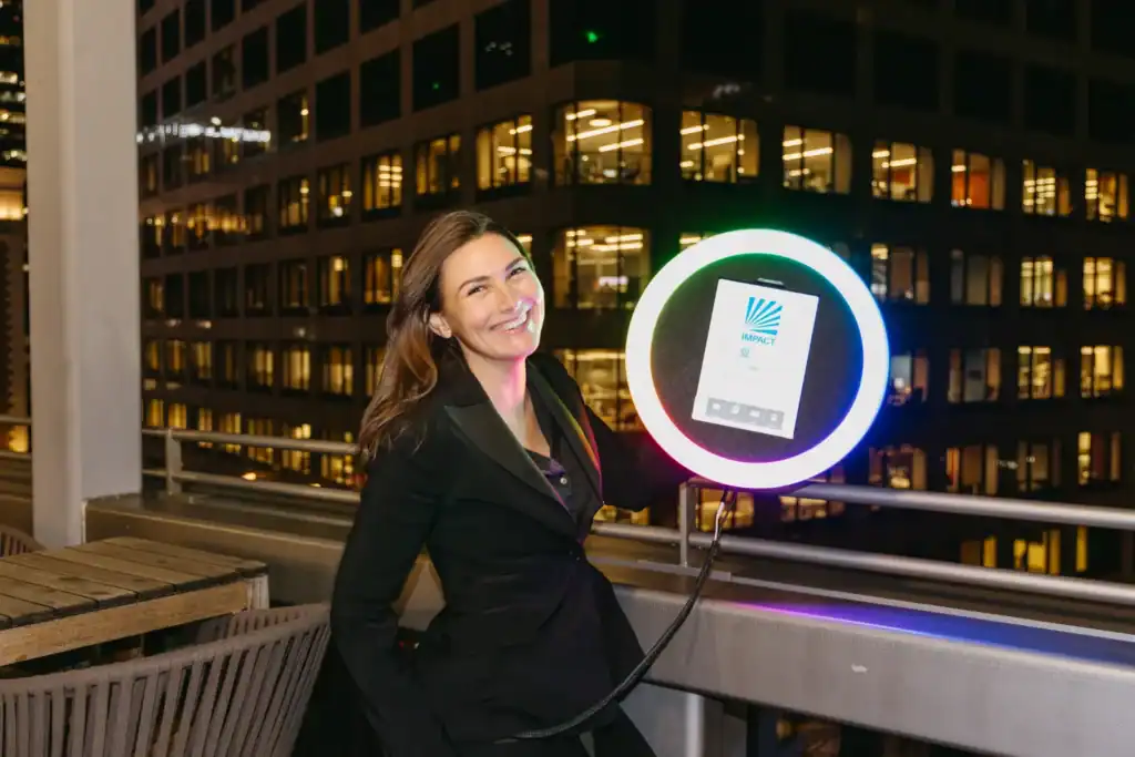 A guest poses beside the Ai Roamer’s ring-light booth for crisp, on-the-spot photos while overlooking the city at night.